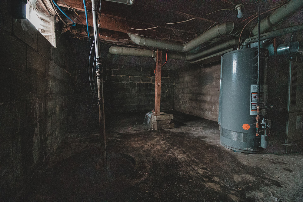 Bare unfinished basement with furnace and pipes.
Asheville basements.